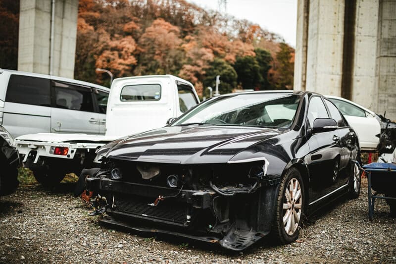 フロントバンパーがつぶれた黒い車